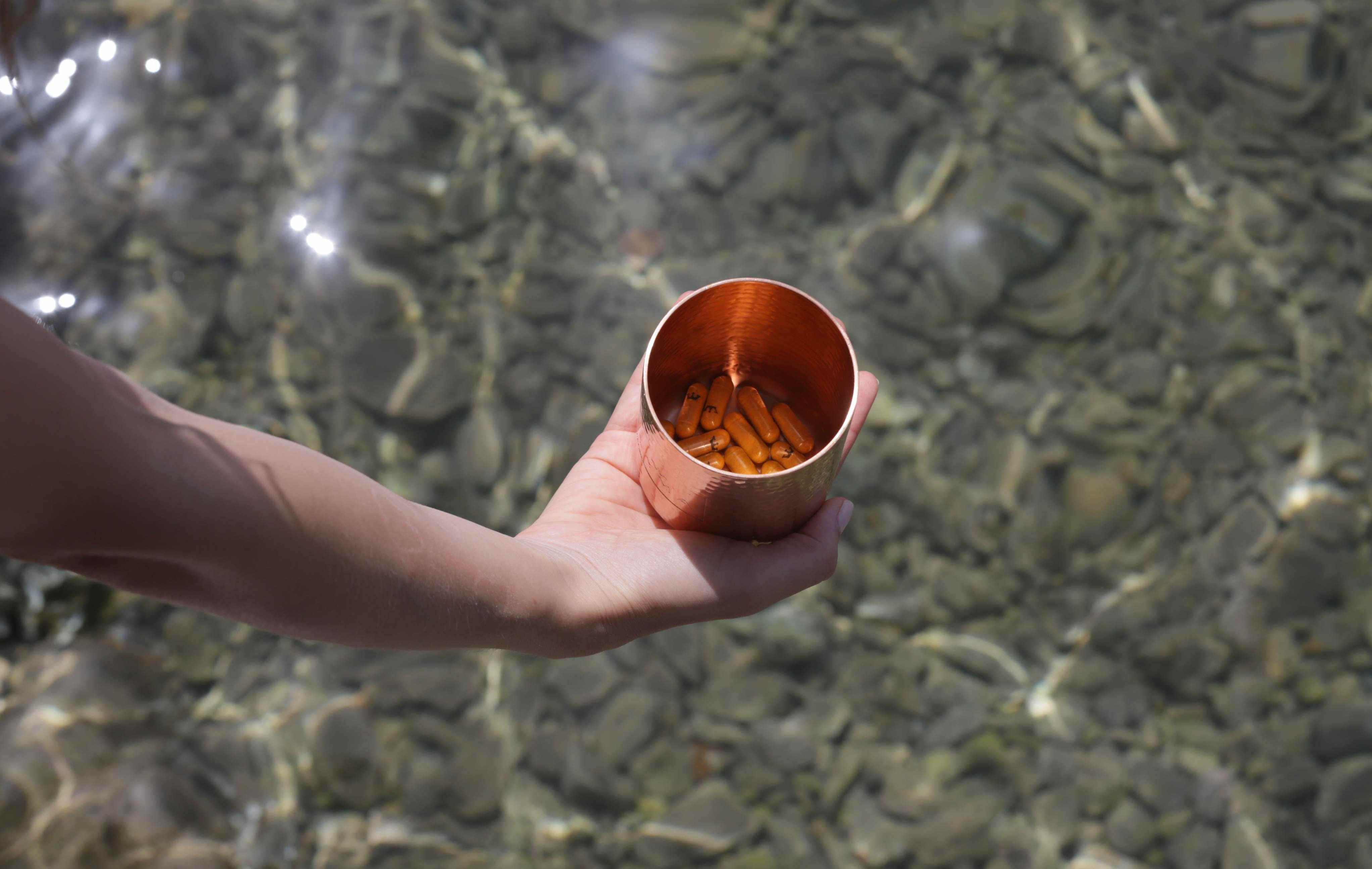 LYMA Supplement jar in hand above water