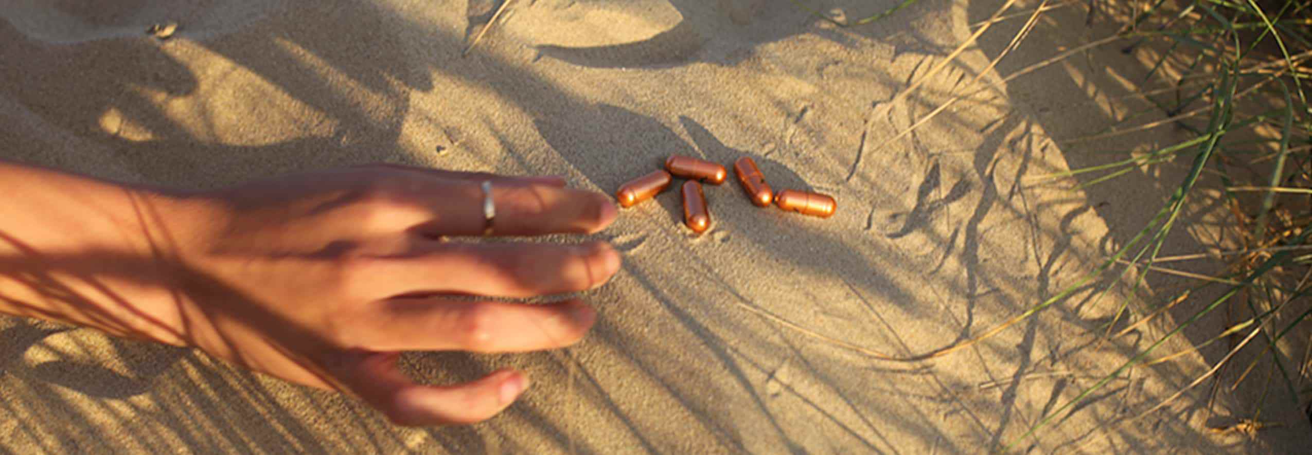 LYMA Energy Vitamins - pills in sand
